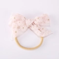 Dettaglio del fiocco in pizzo rosa con ricamo di margherite e fascia elastica in nylon - Rosa