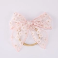 Détail du bandeau en dentelle rose avec broderie marguerite et ruban en nylon élastique - Rose