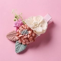 Close-up of pink and cream fabric flowers with green leaves and berries on hair clip - Orange Pink 3D Flower (1)