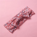 Détail du bandeau élastique en tricot bleu à fleurs avec nœud papillon sur fond rose - Petit Floral Rouge