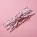 Détail du bandeau fleuri en coton pour bébé avec un nœud doux et imprimé floral violet - Petit Floral Violet