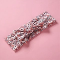 Detail view of baby floral knot headband with soft stretchy cotton fabric and bow - Pink Background Daisy