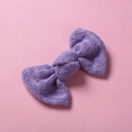 Vue macro détaillée d'une barrette nœud en tricot violet avec motifs de points ajourés fins - 10*6 cm / Violet