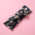Detail of soft floral infant headband with dark blue knot bow on a pink background - Black Floral