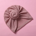 Dettaglio della trama a nido d'ape e del nodo superiore del cappello neonato rosa - Rosa Antico