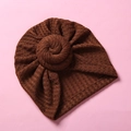 Detail einer braunen Baby-Turbanmütze aus Waffelstrick mit dekorativem Spiralknoten - Braun