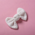 Gros plan détaillé d'une barrette à nœud en dentelle blanche avec texture crochetée - 10*6 cm / Blanc