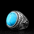 Detail of vintage steel ring featuring a large oval turquoise stone and intricate engravings - US Size 7 / Turquoise
