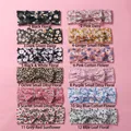 Lot de 12 bandeaux pour bébés avec nœuds floraux de couleurs variées sur fond rose - Mélange Aléatoire