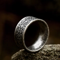 Macro shot of titanium steel ring with black embossed tribal patterns on stone - US Size 7 / Antique Silver