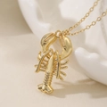 Collier avec pendentif homard doré et finition polie sur un plateau blanc élégant - Style Homard Articulé de Simulation (25145)