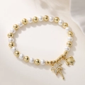 Detailed view of pearl bracelet with crystal coconut tree and turtle charms on fabric - Palm Tree & Turtle Charms Style (32349)
