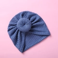 Detailed close-up of navy blue waffle knit infant turban hat with doughnut knot - Blue