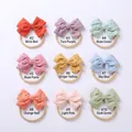 Dettaglio macro di nove fasce per neonati con fiocchi in cotone ricamato colorato - 7.5*5.5 cm / Colori misti casuali