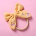 Close-up of yellow bow nylon headband with pink swan embroidery and silver crown detail - Yellow