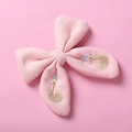 Detail der Schwan-Stickerei mit goldenen Kronen auf pinker Baumwoll-Schleifenspange - Rosa