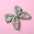 Detailaufnahme einer grünen Schleifen-Haarspange mit rosa Schwanen-Stickerei - Grün