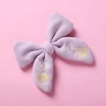 Détail d'une pince à cheveux nœud tricoté lilas avec broderie de cygne et couronne - Violet