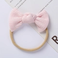 Detail of pink waffle knit baby headband with elastic nylon loop and soft bow texture - Pink