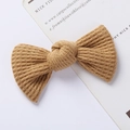 Detailed view of a khaki waffle-knit bow hair clip with fine ribbed texture on a white card - Waffle Texture Bow / Tan