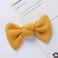 Detailed shot of yellow knitted bow hair clip featuring soft waffle knit texture - Ribbed Texture Bow / Bright yellow