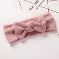 Gros plan sur un bandeau bébé en maille côtelée rose avec un grand nœud décoratif - 17x7cm / Rose Poudré