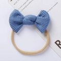 Detail view showing blue waffle knit texture and soft nylon band on a baby bow headband - Blue