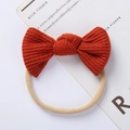 Detail of the orange waffle knit bow headband with elastic nude nylon band for babies - Orange Red