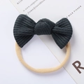Detailed close-up of dark green waffle knit bow headband with elastic nude band - Dark Green