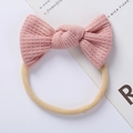 Detailed close-up of pink waffle knit bow headband with elastic seamless nylon band - Pink