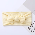 Detail of light yellow knitted baby headband with a jacquard bow on a white background - 17.5*7.5 cm / Beige