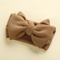 Detail of baby waffle knit headband with large bow in dark camel showing fabric texture - 17*9 cm / Earthy Yellow