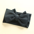 Detail showing the waffle knit texture of a charcoal grey oversized baby headband bow - 17*9 cm / Dark Green
