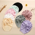 Flat lay of colorful eyelet lace baby turban hats featuring large bows in eight colors - Random Color