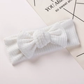 White ribbed knit baby headband featuring a large bow design and soft elastic texture - White