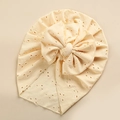 Detail of baby turban hat with delicate hollow eyelet embroidery and a large bow - Beige