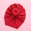 Detailed view of red donut-style ribbed knit baby turban hat with front twisted knot - Red