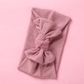 Detail shot of soft pink ribbed knit baby headband featuring a large bow knot accessory - Dark Dusty Pink