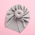 Macro detail of a light grey baby donut turban hat with vertical ribbed knit and pleats - Gray