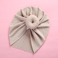 Close-up of beige ribbed knit baby turban hat with donut knot on pink background - Khaki