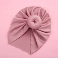 Detail of baby turban hat featuring a pink donut knot and elastic ribbed knit fabric - Deep Pink