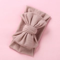 Detail of soft ribbed knit baby headband with oversized bow in dusty rose color - Flesh Pink