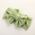 Détail d'un bandeau pour bébé vert clair en maille côtelée avec un grand nœud - 16X8cm / Vert Émeraude