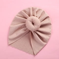 Detailed view of the dusty pink ribbed knit baby turban featuring a donut-style top knot - Nude Pink