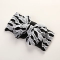 Détail d'un bandeau bébé en tissu noir avec nœud papillon en dentelle blanche à volants - 16X8cm / Blanc & Noir