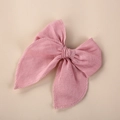 Gros plan d'un nœud papillon en lin rose avec bord brodé et texture de tissu fin - Rose Clair