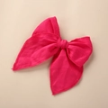 Détail de la barrette nœud en lin rose vif montrant les finitions brodées de qualité - Rose rouge