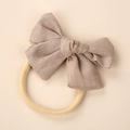Close-up of linen bow headband with soft nylon strap for newborn baby skin - Khaki