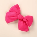 Détail du nœud à cheveux en lin rose fuchsia montrant la texture du tissu et le nouage - 9x8cm / Rose Rouge