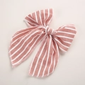 Detail of red and cream striped bow hair clip made of high-quality coarse textured fabric - Red